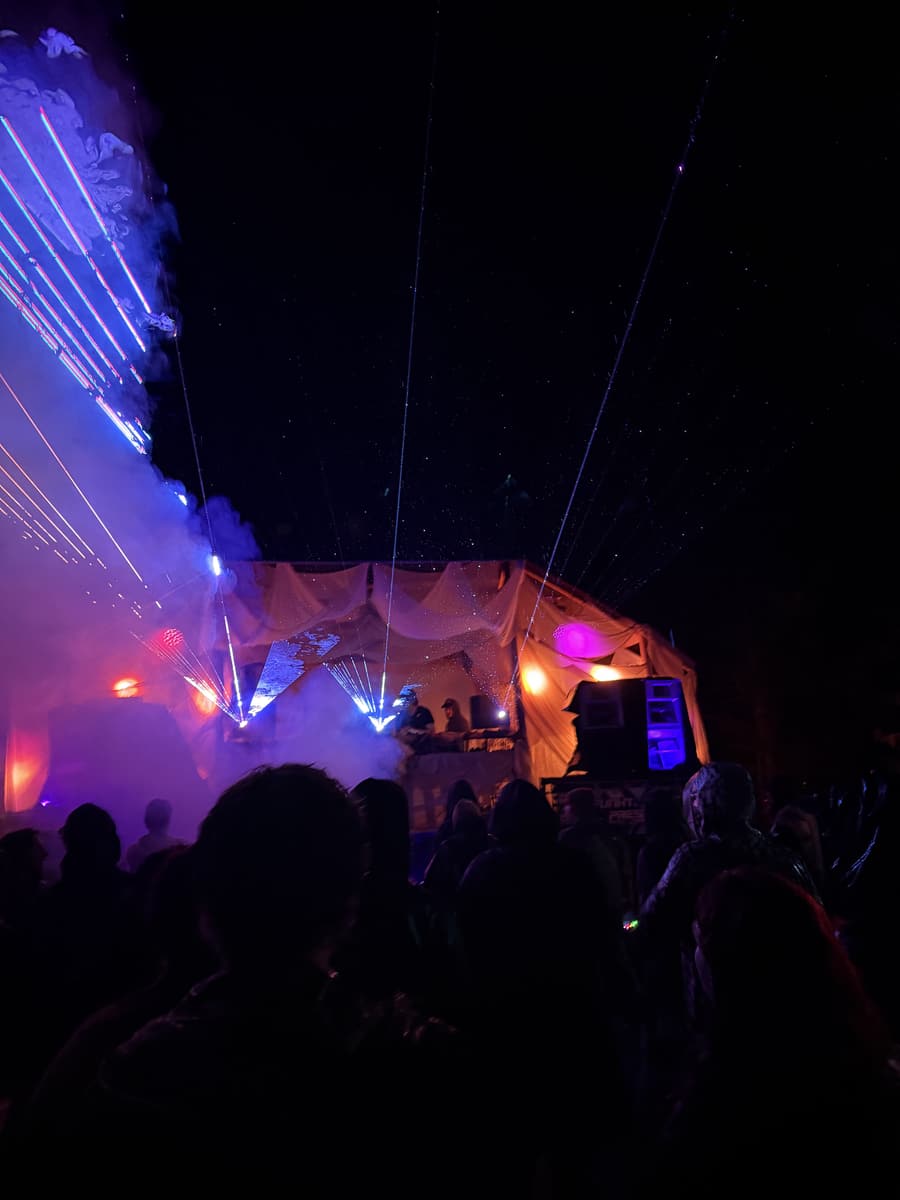 Night stage with light beams and a crowd in the foreground