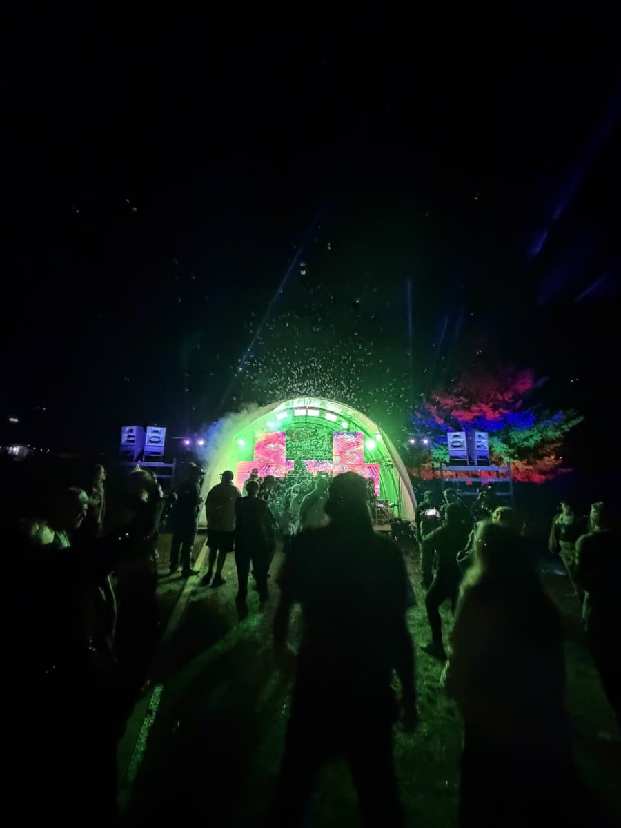 Dome stage lit green with the crowd in silhouette