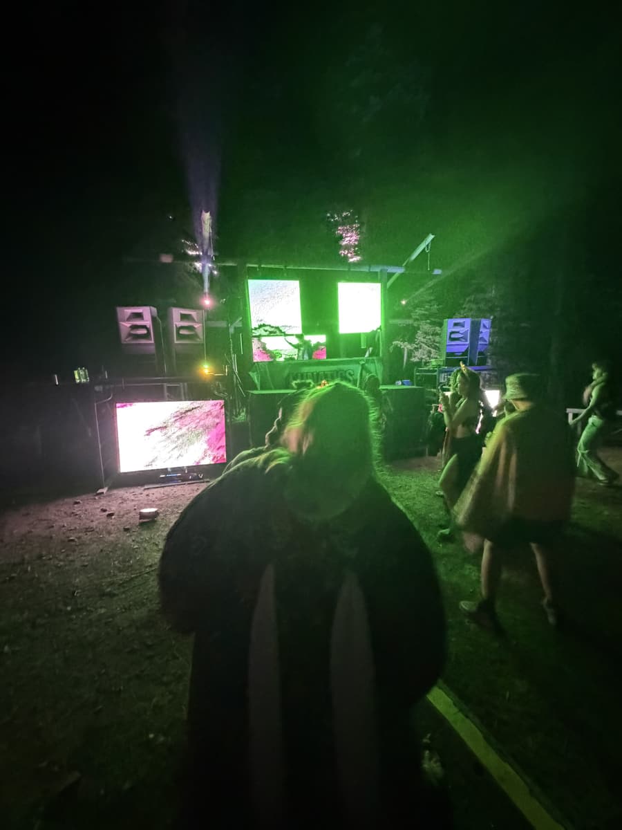Green-lit stage with dancers in front of the rig